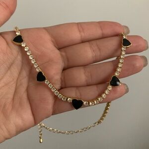 Goldtone tennis choker with enamel black heart stations